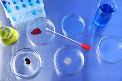 Photo of Petri dishes and flasks with samples on table, above view