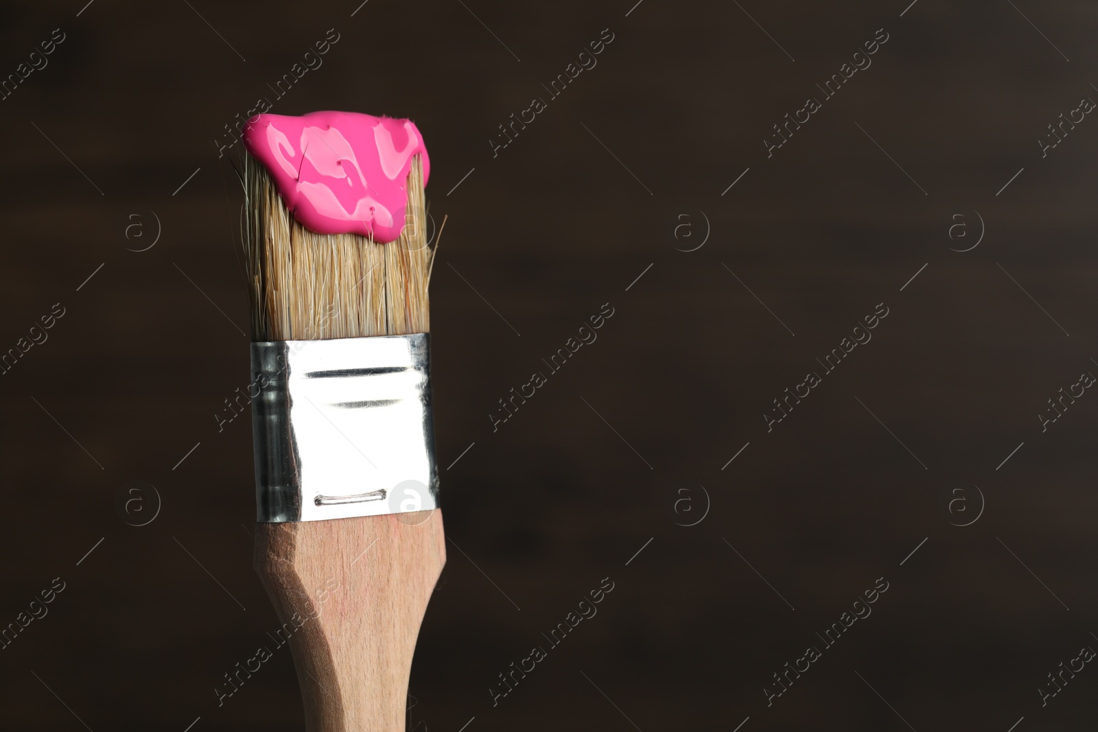 Brush with pink paint on wooden background, closeup. Space for text Photo of Brush with pink paint on wooden background, closeup. Space for text