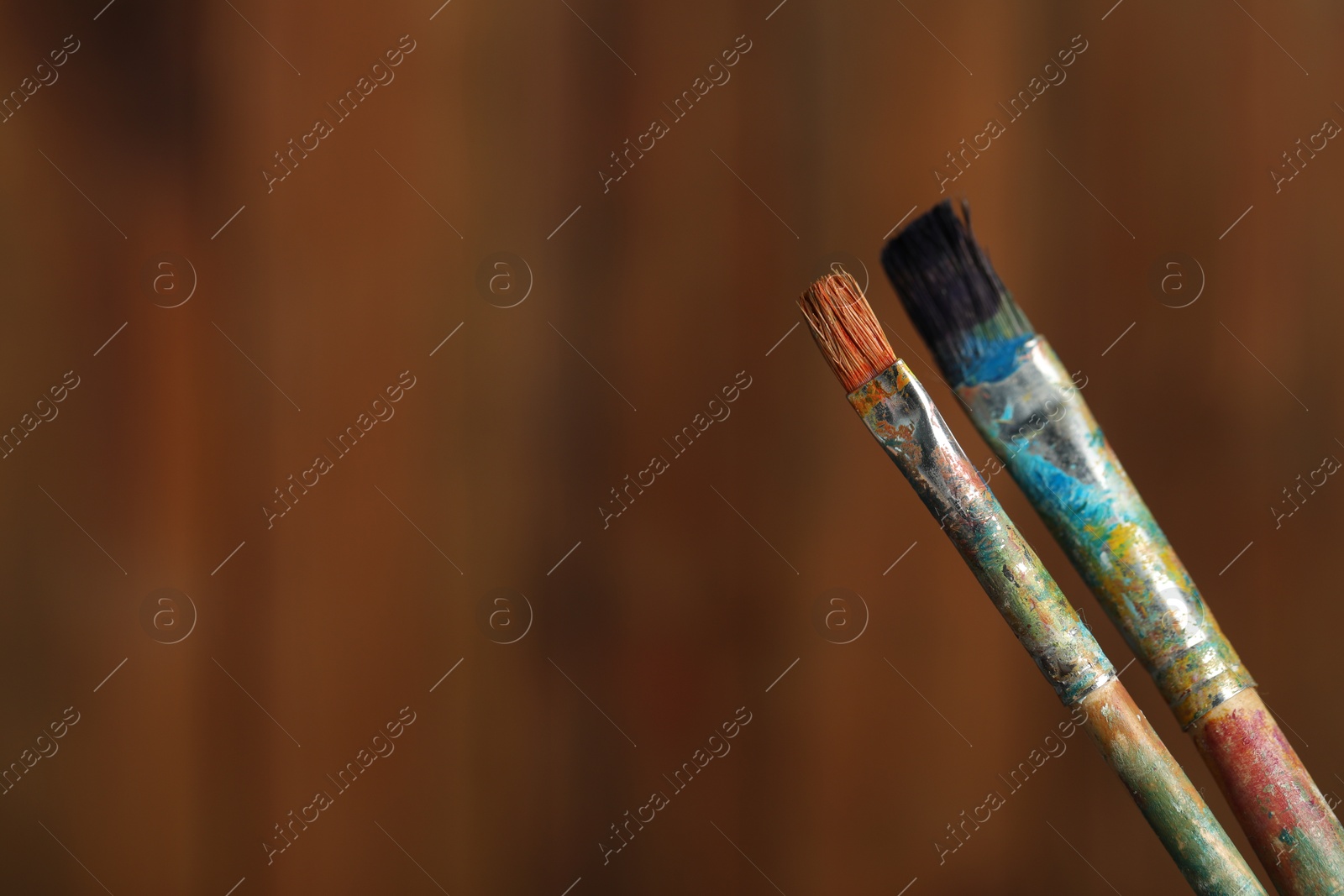 Two dirty paintbrushes on wooden background, closeup. Space for text Photo of Two dirty paintbrushes on wooden background, closeup. Space for text