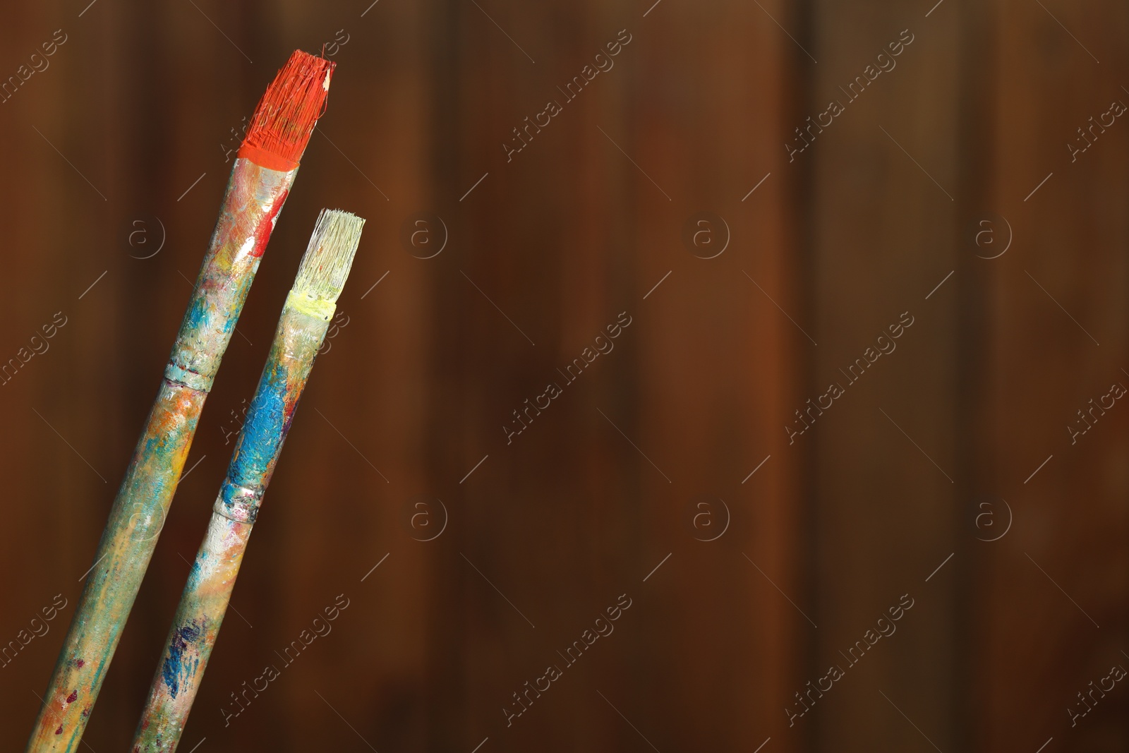 Two dirty paintbrushes on wooden background, closeup. Space for text Photo of Two dirty paintbrushes on wooden background, closeup. Space for text