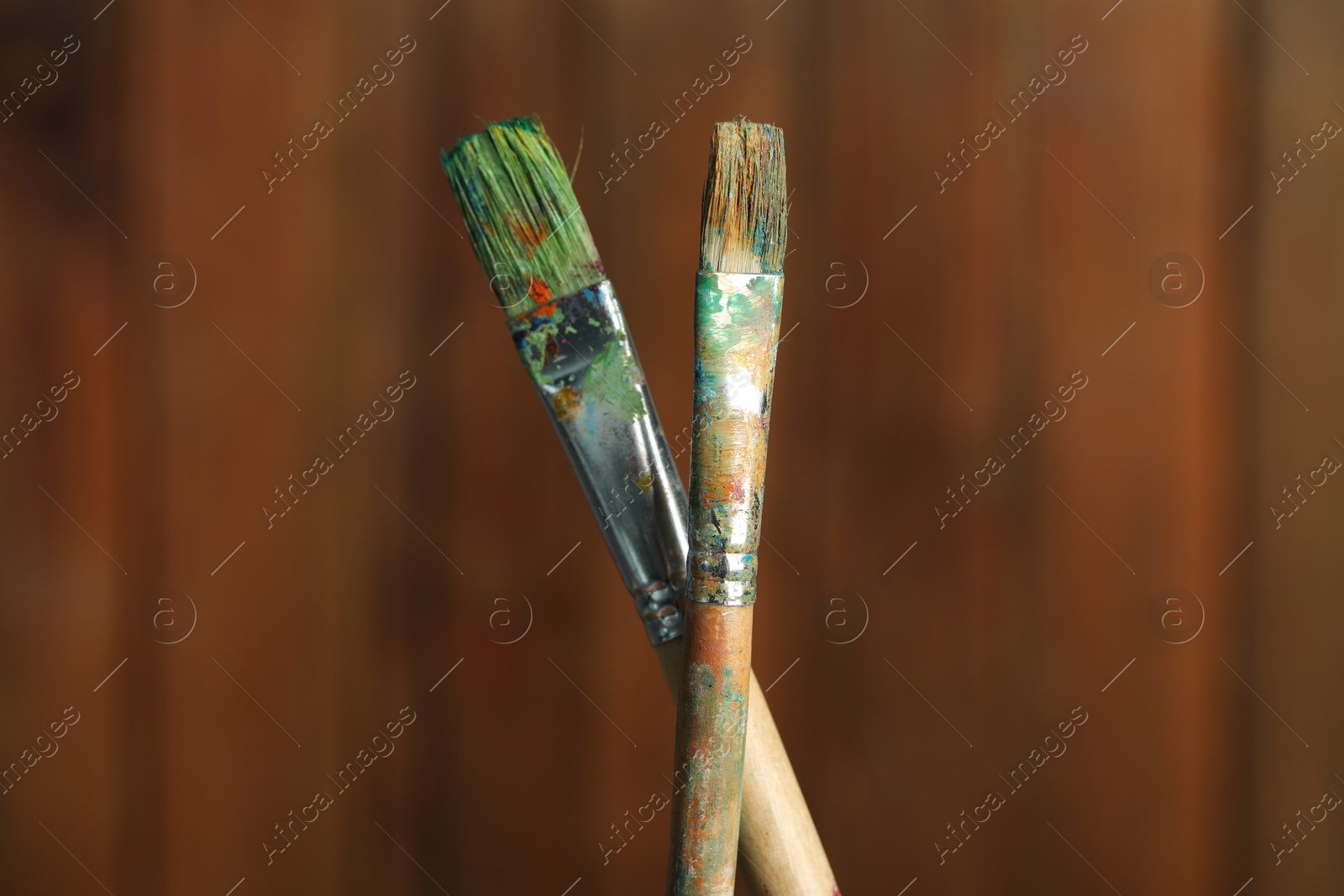 Two dirty paintbrushes on wooden background, closeup Photo of Two dirty paintbrushes on wooden background, closeup