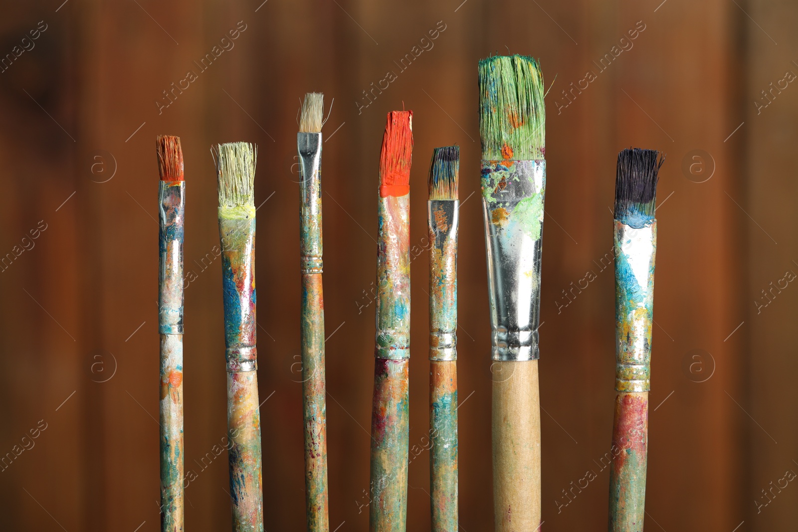 Many dirty paintbrushes on wooden background, closeup Photo of Many dirty paintbrushes on wooden background, closeup