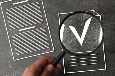 Image of Woman looking through magnifying glass on virtual approved document with check mark on grey textured background, top view