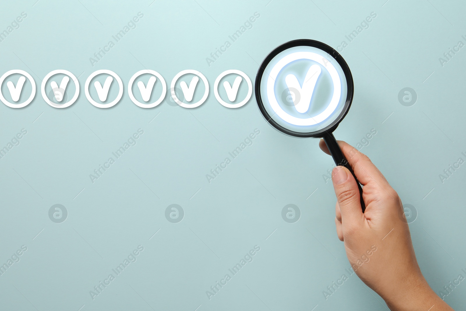 Approved. Woman holding magnifying glass over check mark on light blue background, top view Image of Approved. Woman holding magnifying glass over check mark on light blue background, top view