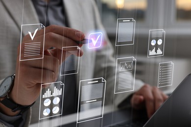 Image of Man approving documents on virtual screen above laptop at table, closeup