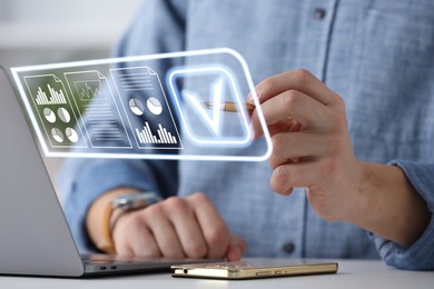 Image of Man approving documents on virtual screen above laptop at table, closeup