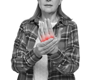 Image of Arthritis. Senior woman suffering from pain in hand on white background, closeup. Black and white toning with red color accent