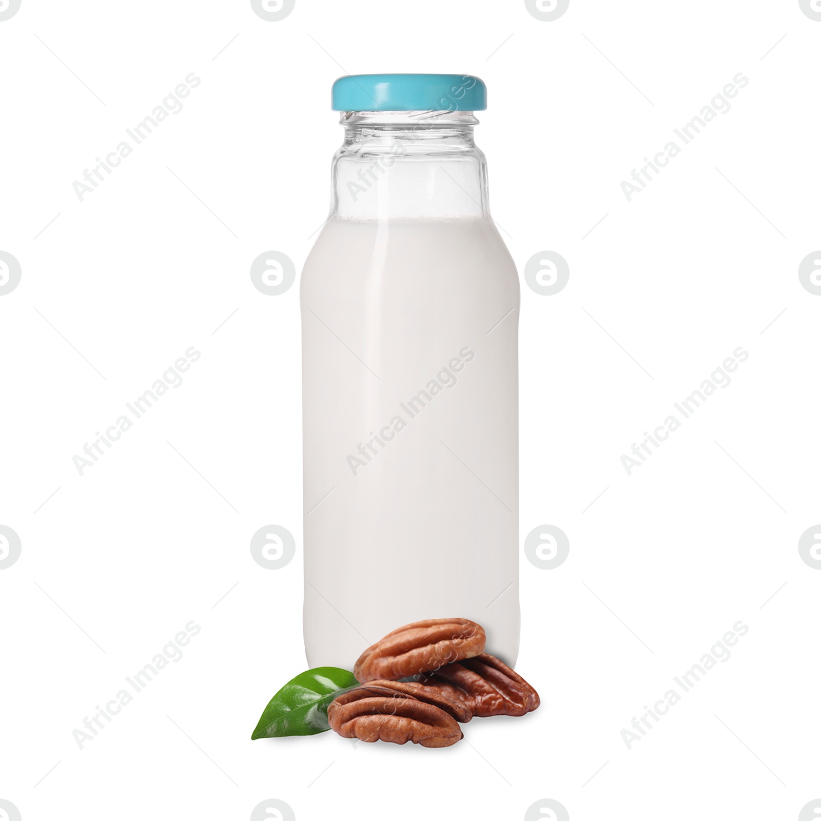 Nut milk in glass bottle and pecans isolated on white Image of Nut milk in glass bottle and pecans isolated on white
