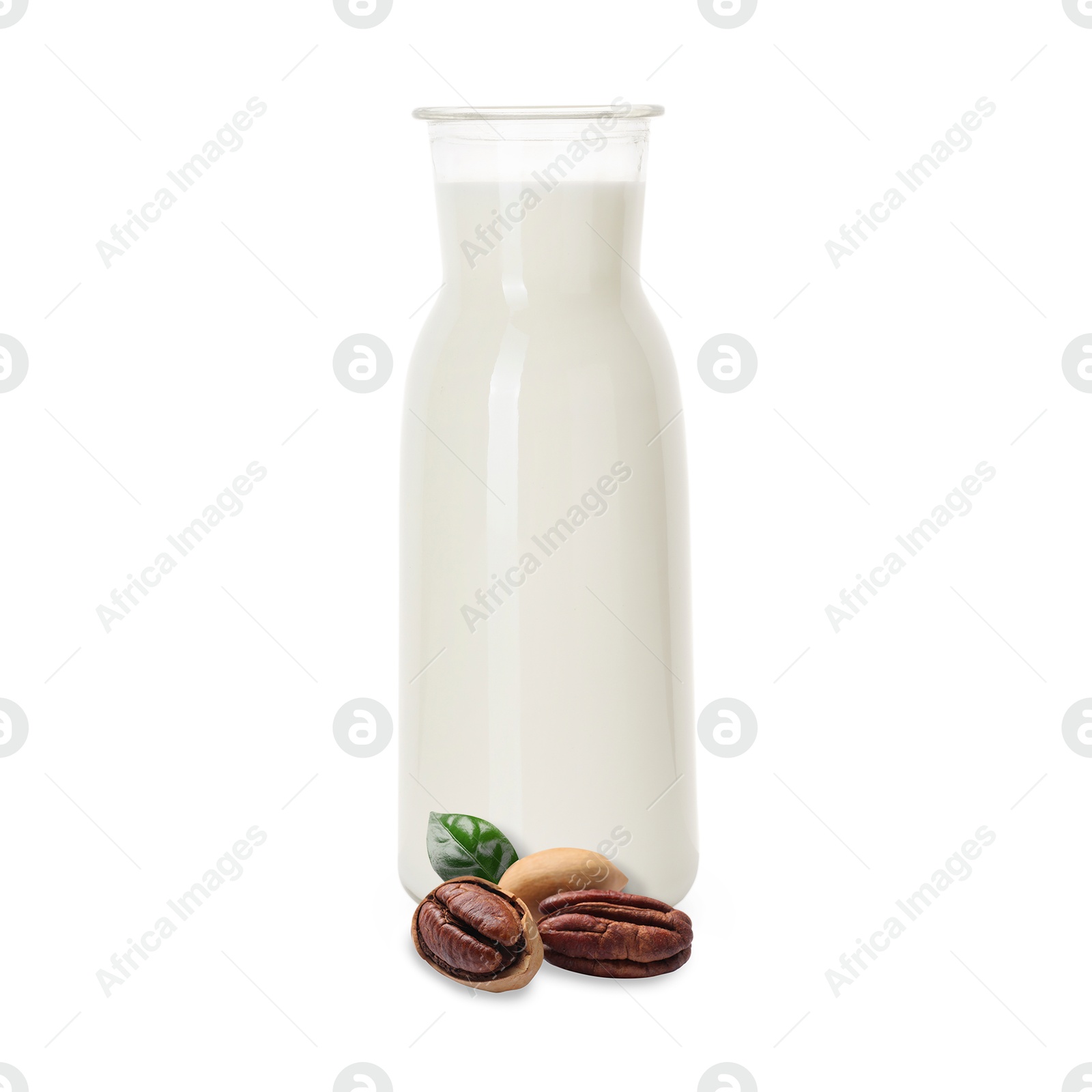 Nut milk in glass bottle and pecans isolated on white Image of Nut milk in glass bottle and pecans isolated on white