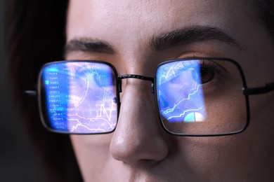 Image of Stock exchange. Trader analyzing data, closeup. Graphs and information reflecting in her eyeglasses