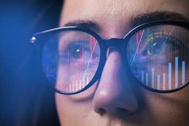 Image of Stock exchange. Trader analyzing data, closeup. Graphs reflecting in her eyeglasses