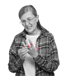 Image of Arthritis. Senior woman suffering from pain in fingers on white background. Black and white toning with red color accent