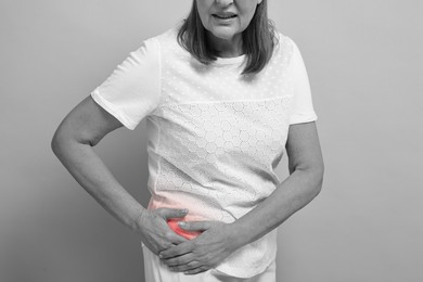 Image of Arthritis. Senior woman suffering from hip joint pain, closeup. Black and white toning with red color accent