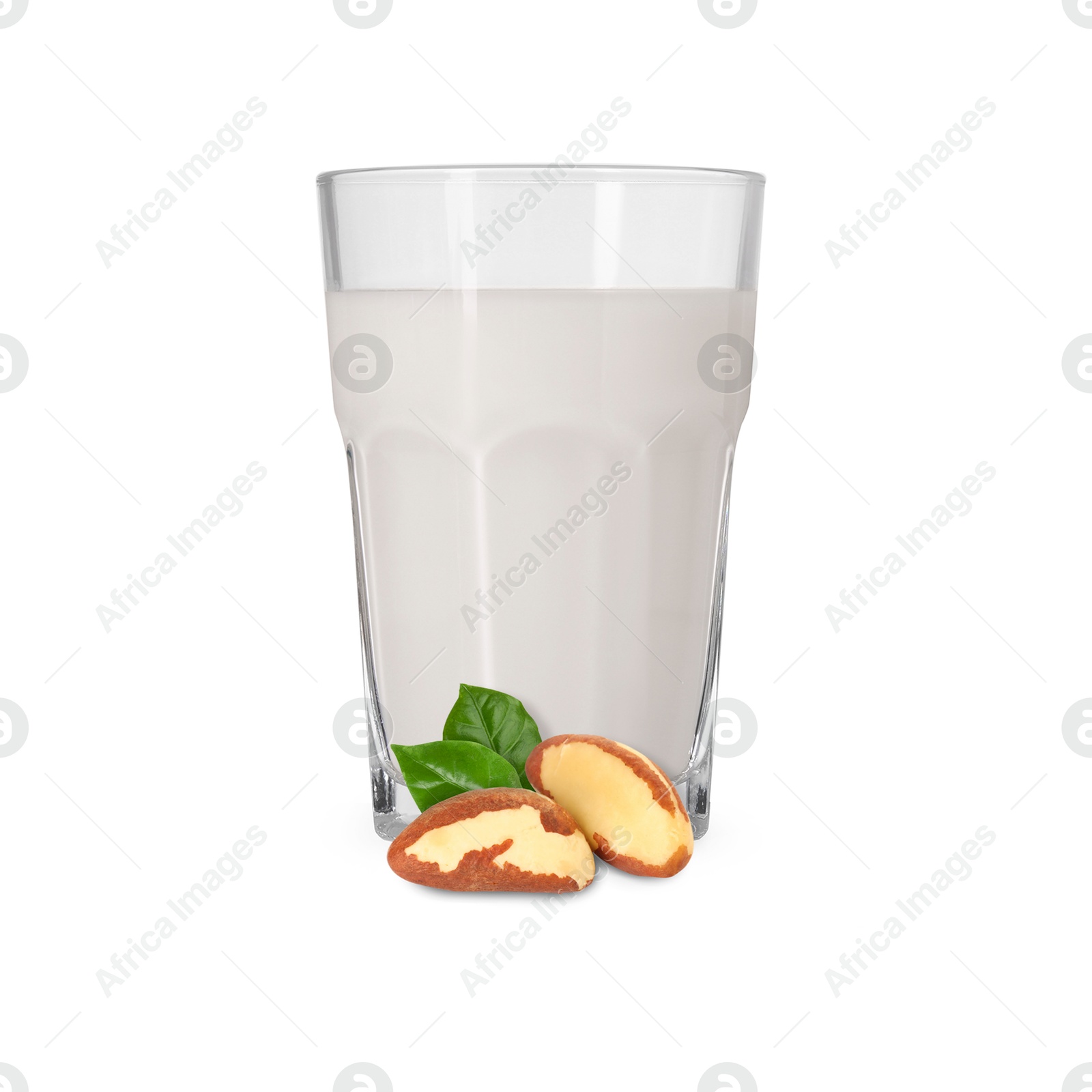 Nut milk in glass and Brazil nuts isolated on white Image of Nut milk in glass and Brazil nuts isolated on white