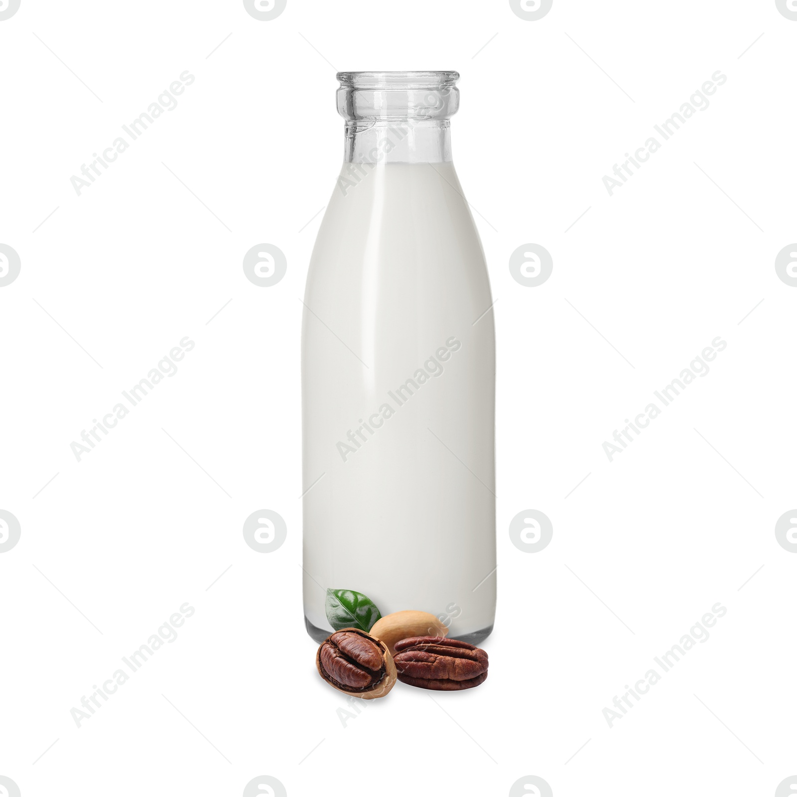 Nut milk in glass bottle and pecans isolated on white Image of Nut milk in glass bottle and pecans isolated on white