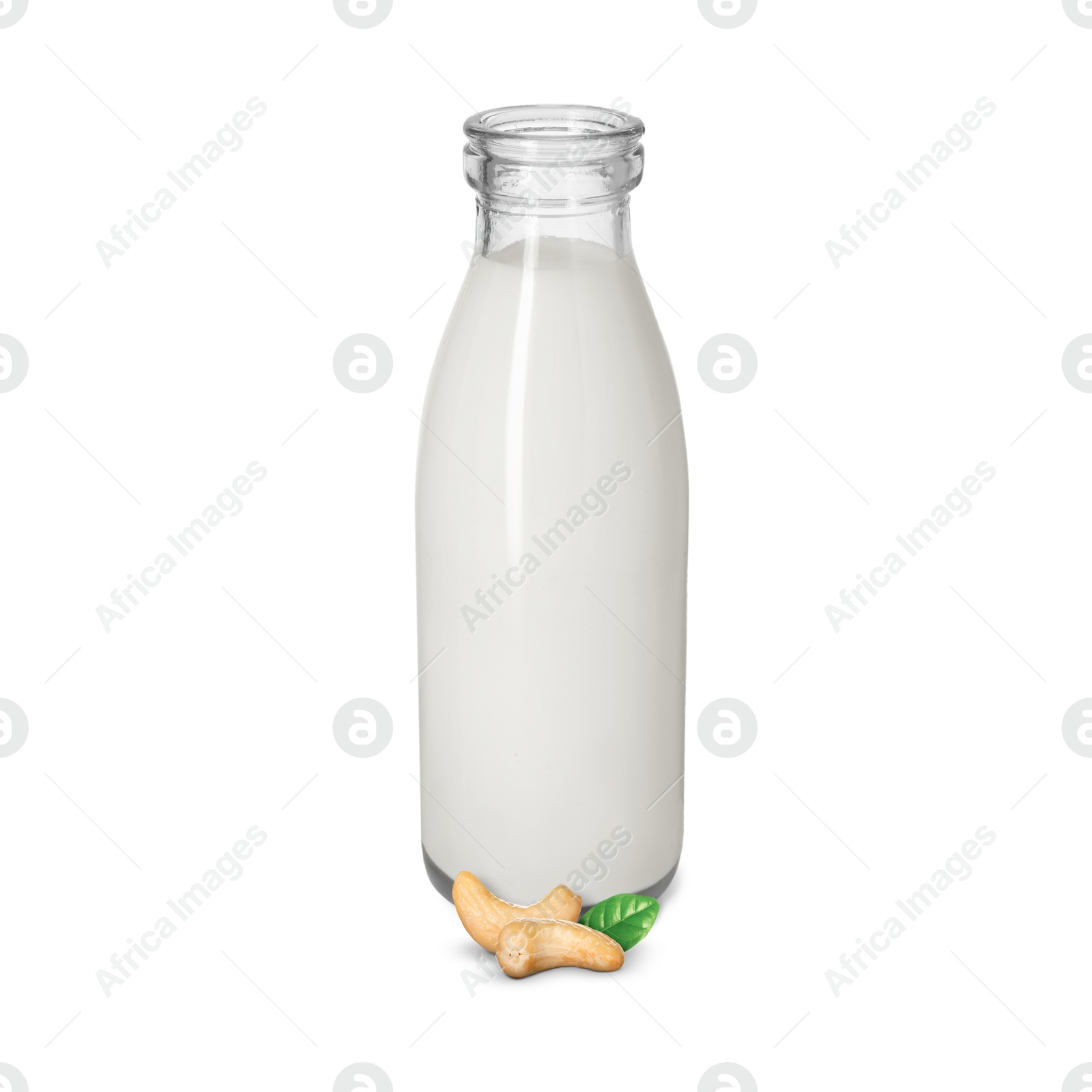 Nut milk in glass bottle and cashews isolated on white Image of Nut milk in glass bottle and cashews isolated on white
