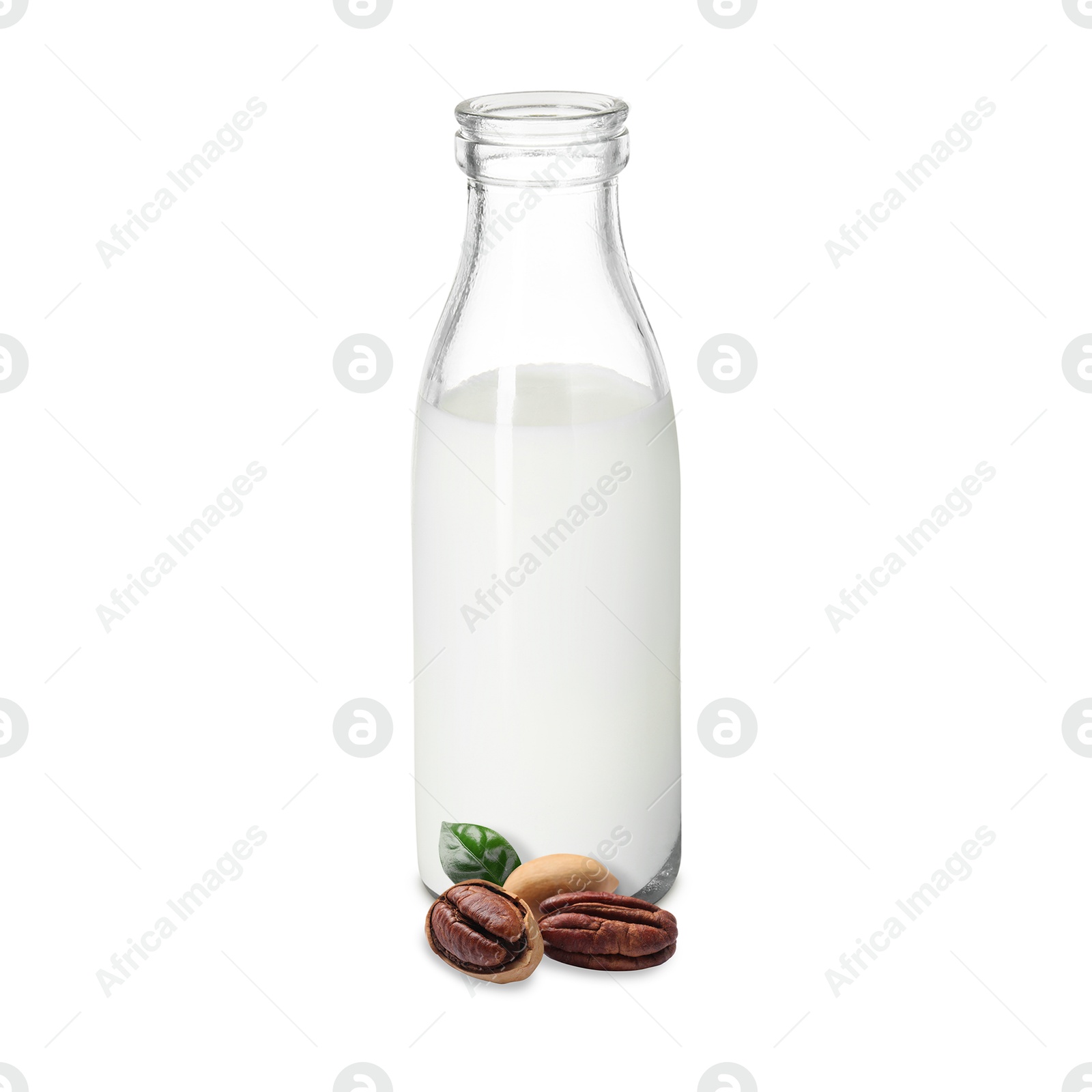 Nut milk in glass bottle and pecans isolated on white Image of Nut milk in glass bottle and pecans isolated on white