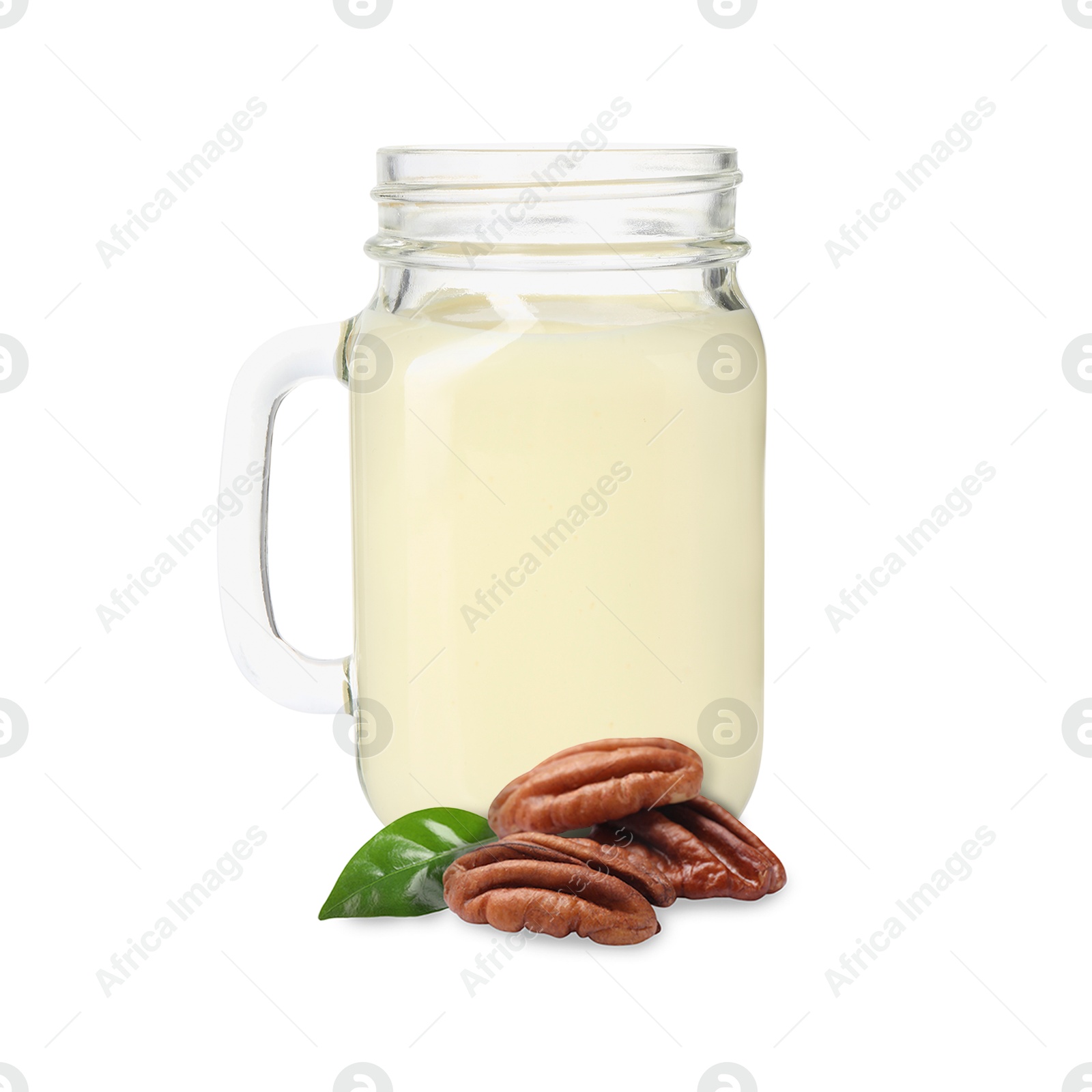 Nut milk in glass jar and pecans isolated on white Image of Nut milk in glass jar and pecans isolated on white