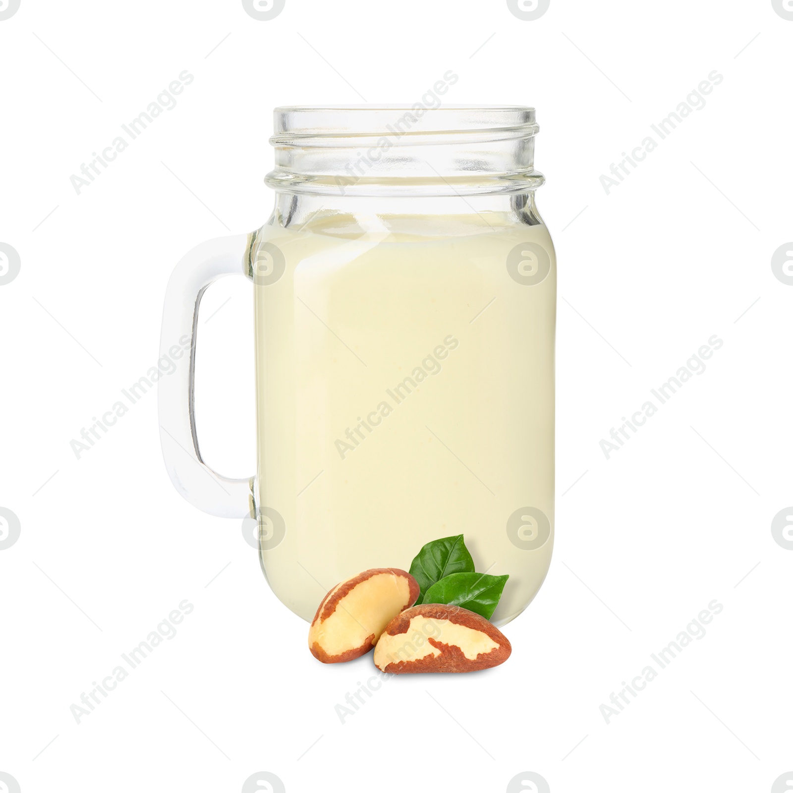 Nut milk in glass jar and Brazil nuts isolated on white Image of Nut milk in glass jar and Brazil nuts isolated on white