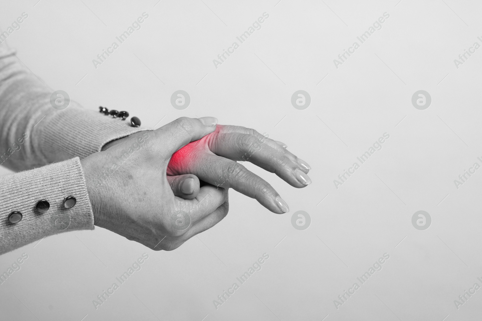 Arthritis. Woman suffering from pain in hand, closeup. Black and white toning with red color accent Image of Arthritis. Woman suffering from pain in hand, closeup. Black and white toning with red color accent
