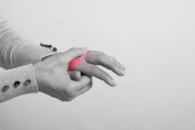 Image of Arthritis. Woman suffering from pain in hand, closeup. Black and white toning with red color accent