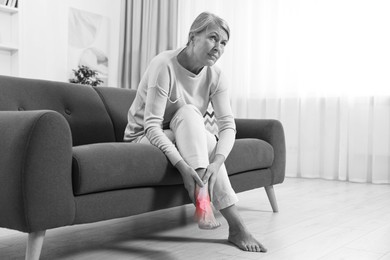 Image of Arthritis. Senior woman suffering from pain in leg at home. Black and white toning with red color accent