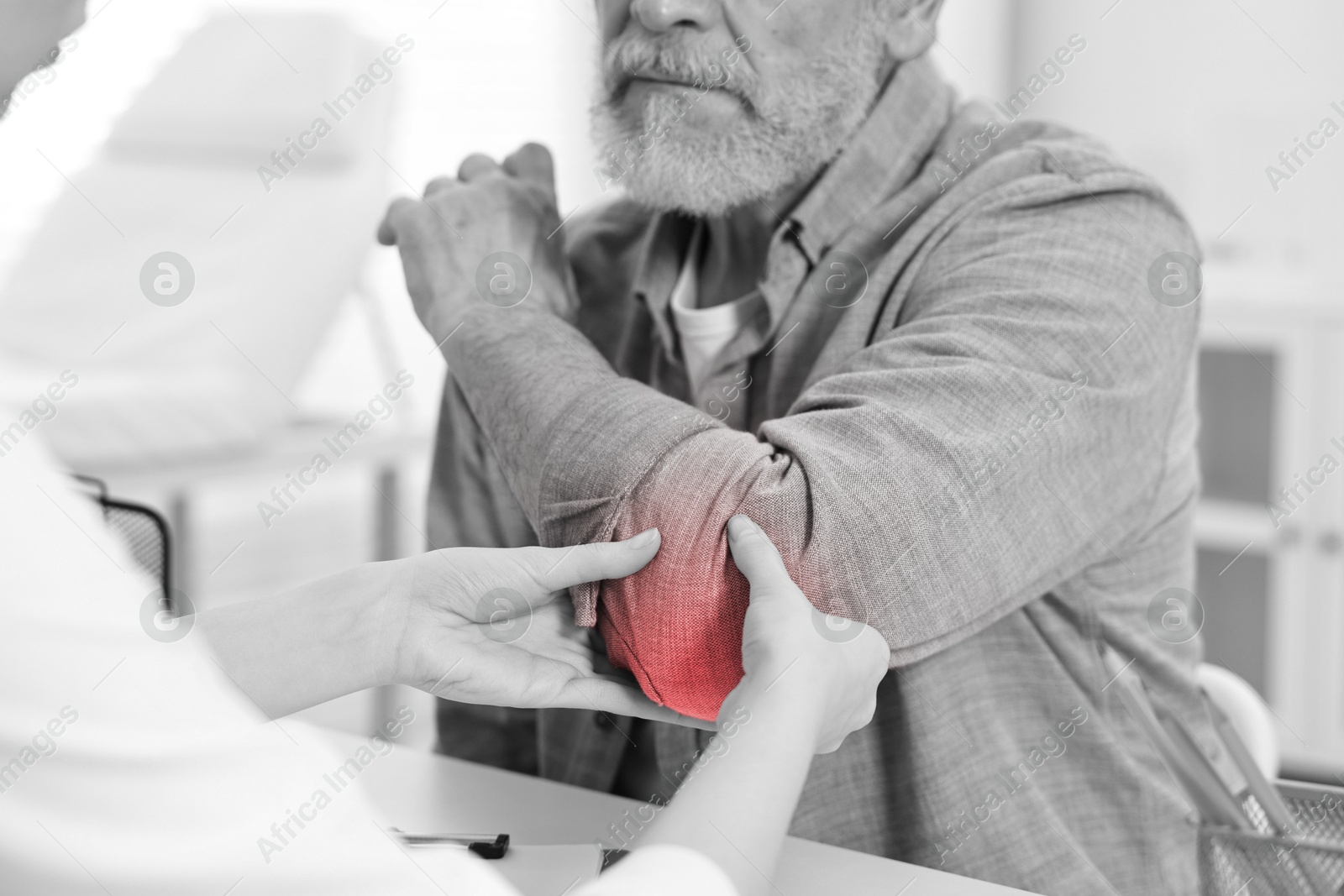 Arthritis. Doctor examining patient's elbow in hospital, closeup. Black and white toning with red color accent Image of Arthritis. Doctor examining patient's elbow in hospital, closeup. Black and white toning with red color accent