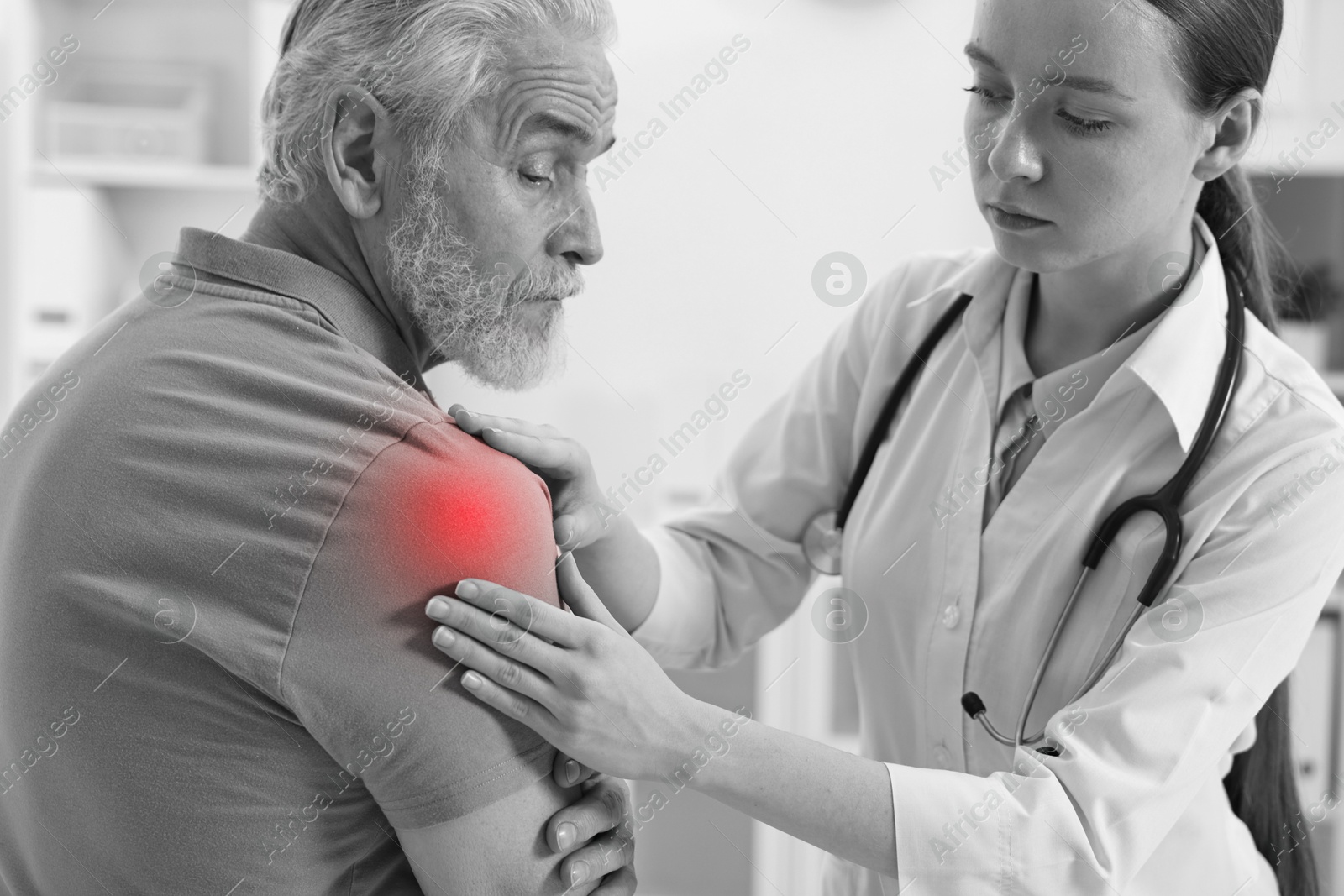 Arthritis. Doctor examining patient with shoulder pain in hospital. Black and white toning with red color accent Image of Arthritis. Doctor examining patient with shoulder pain in hospital. Black and white toning with red color accent
