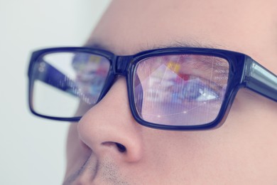 Image of Stock exchange. Trader analyzing data, closeup. Graphs reflecting in his eyeglasses