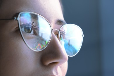 Image of Stock exchange. Trader analyzing data, closeup. Graphs reflecting in her eyeglasses