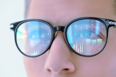 Image of Stock exchange. Trader analyzing data, closeup. Graphs and information reflecting in his eyeglasses