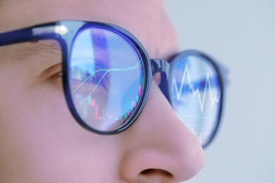 Image of Stock exchange. Trader analyzing data, closeup. Graphs reflecting in his eyeglasses