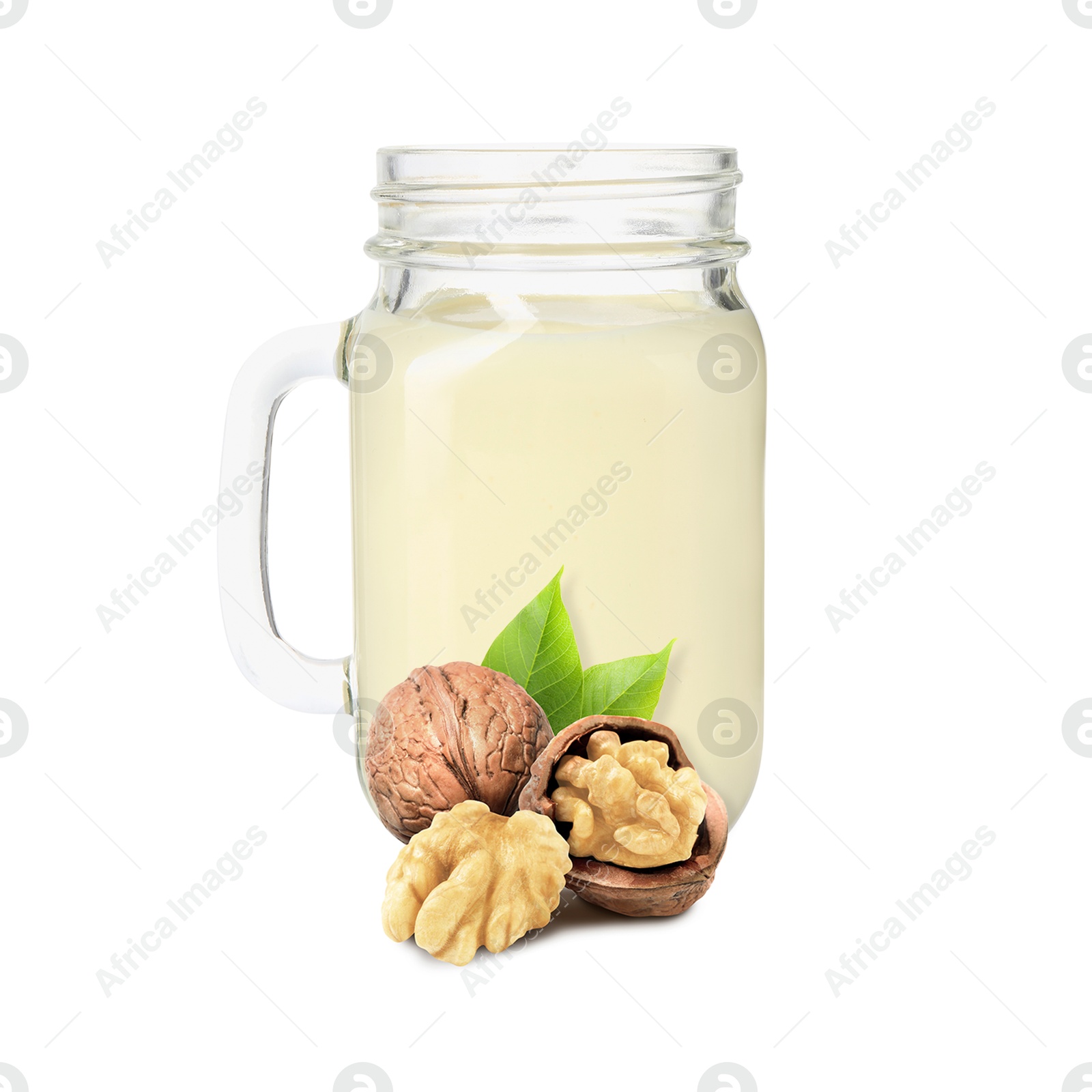 Nut milk in glass jar and walnuts isolated on white Image of Nut milk in glass jar and walnuts isolated on white