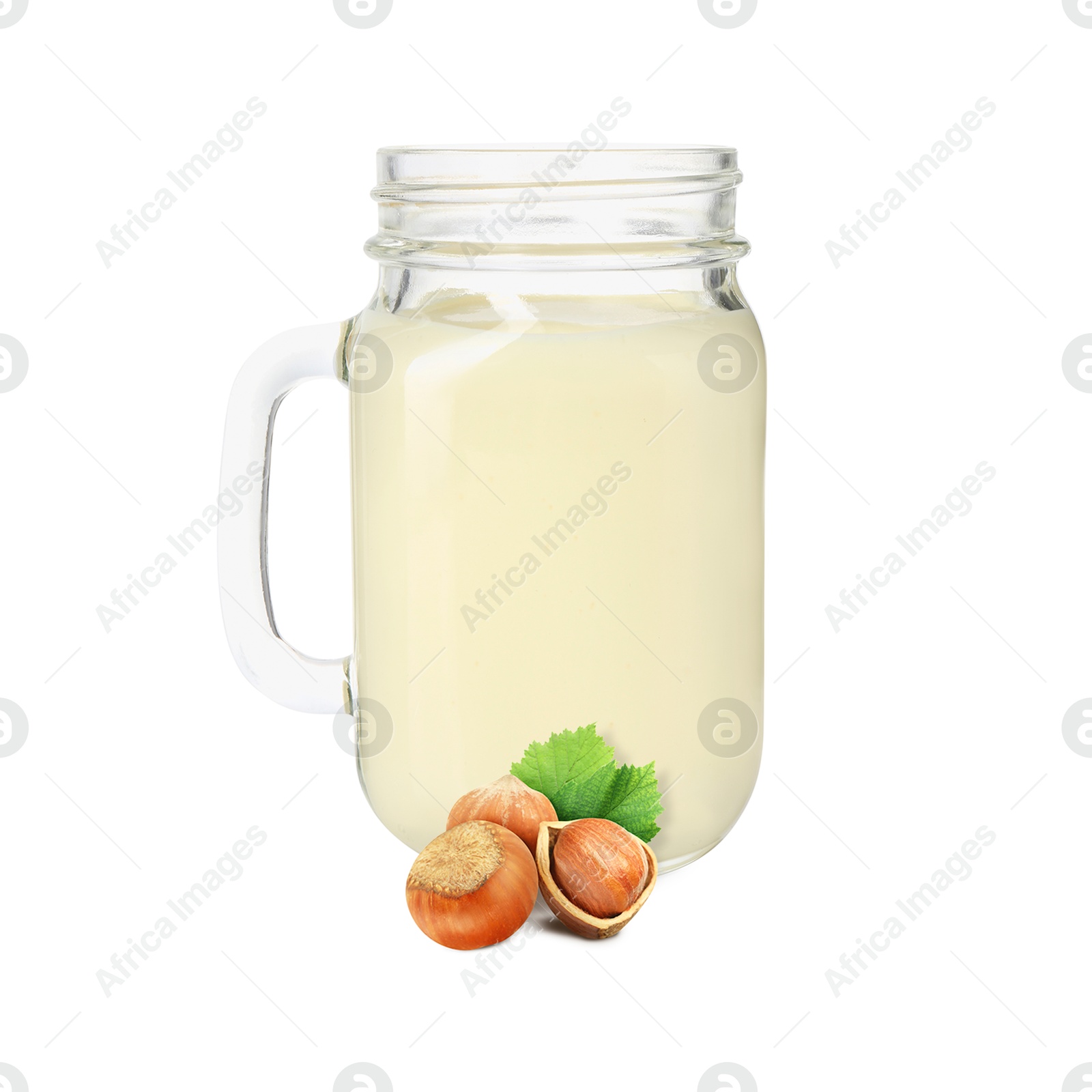 Nut milk in glass jar and hazelnuts isolated on white Image of Nut milk in glass jar and hazelnuts isolated on white