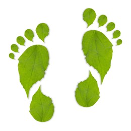 Image of Human footprints made of green leaves on white background, top view. Environmental care, ecology protection, reducing CO2 emission
