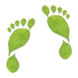 Image of Human footprints made of green leaves on white background, top view. Environmental care, ecology protection, reducing CO2 emission