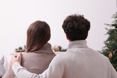 Photo of Couple watching movie via video projector at home, back view