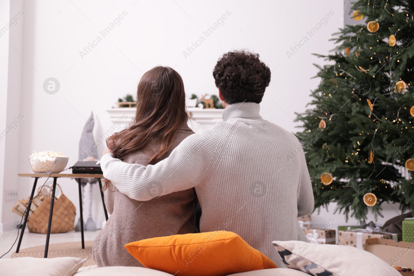 Couple watching movie via video projector at home, back view Photo of Couple watching movie via video projector at home, back view