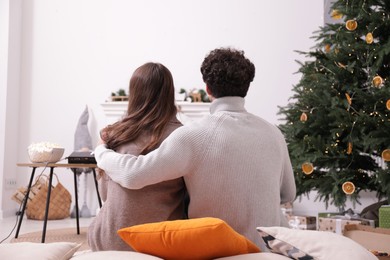 Photo of Couple watching movie via video projector at home, back view