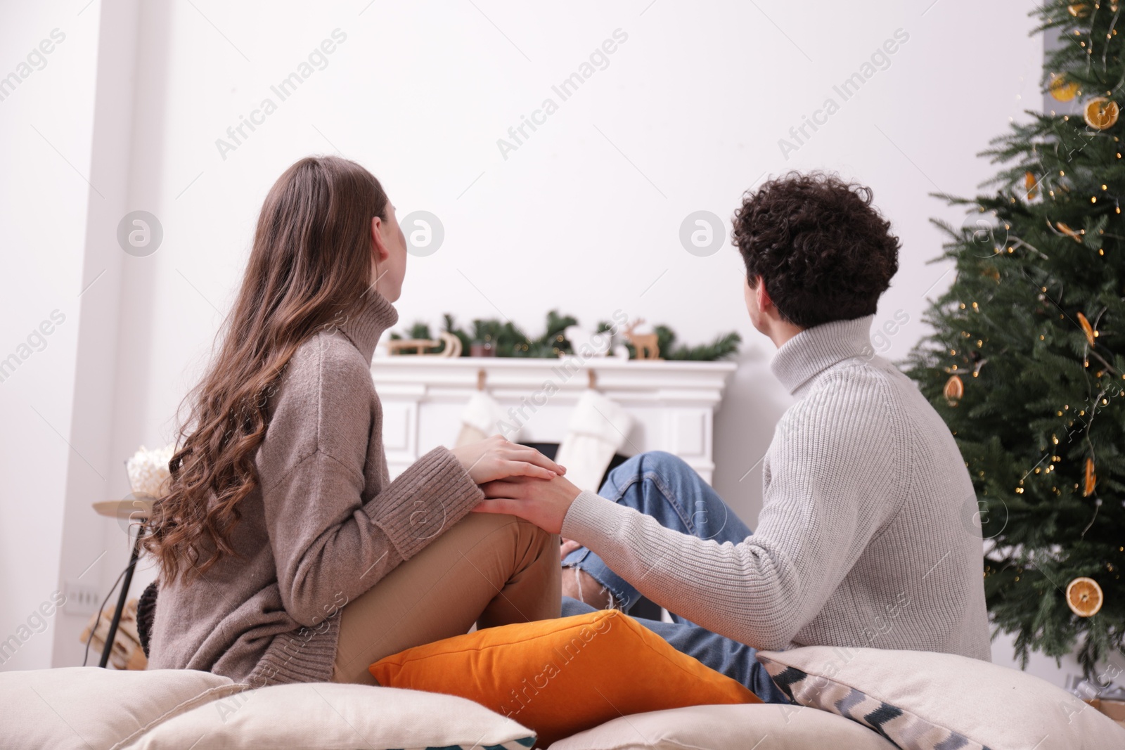 Couple holding hands together and watching movie via video projector at home Photo of Couple holding hands together and watching movie via video projector at home