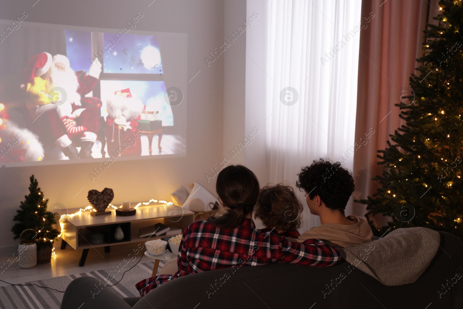 Family watching Christmas movie via video projector at home Photo of Family watching Christmas movie via video projector at home