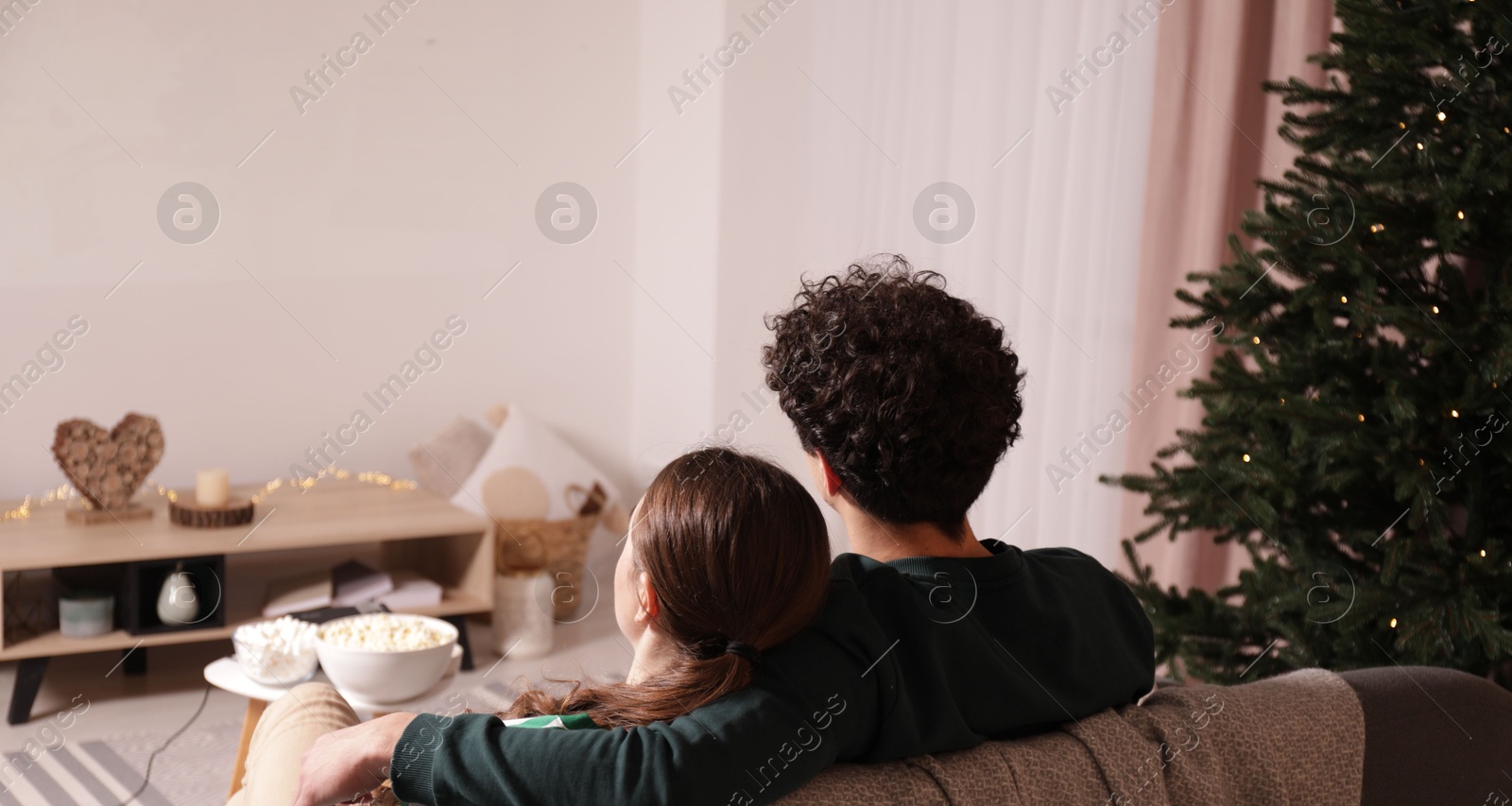 Couple watching romantic Christmas movie via video projector at home Photo of Couple watching romantic Christmas movie via video projector at home
