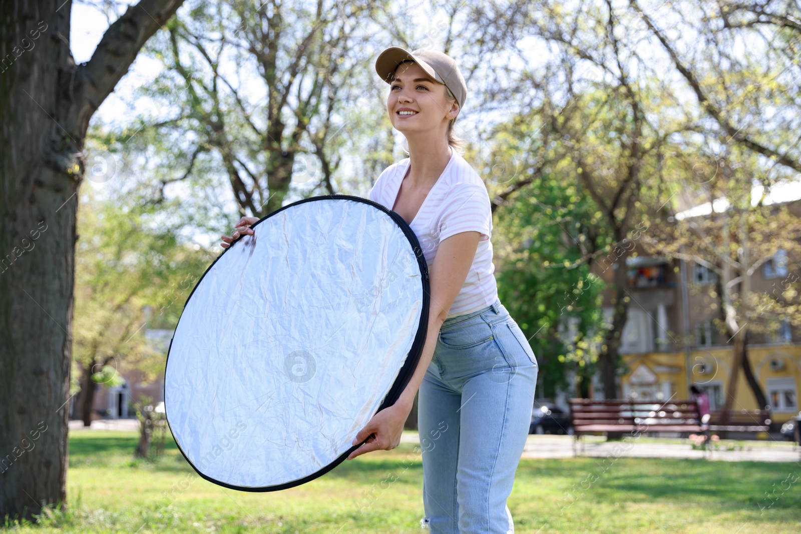 Woman with reflector outdoors on sunny day. Photography equipment Photo of Woman with reflector outdoors on sunny day. Photography equipment