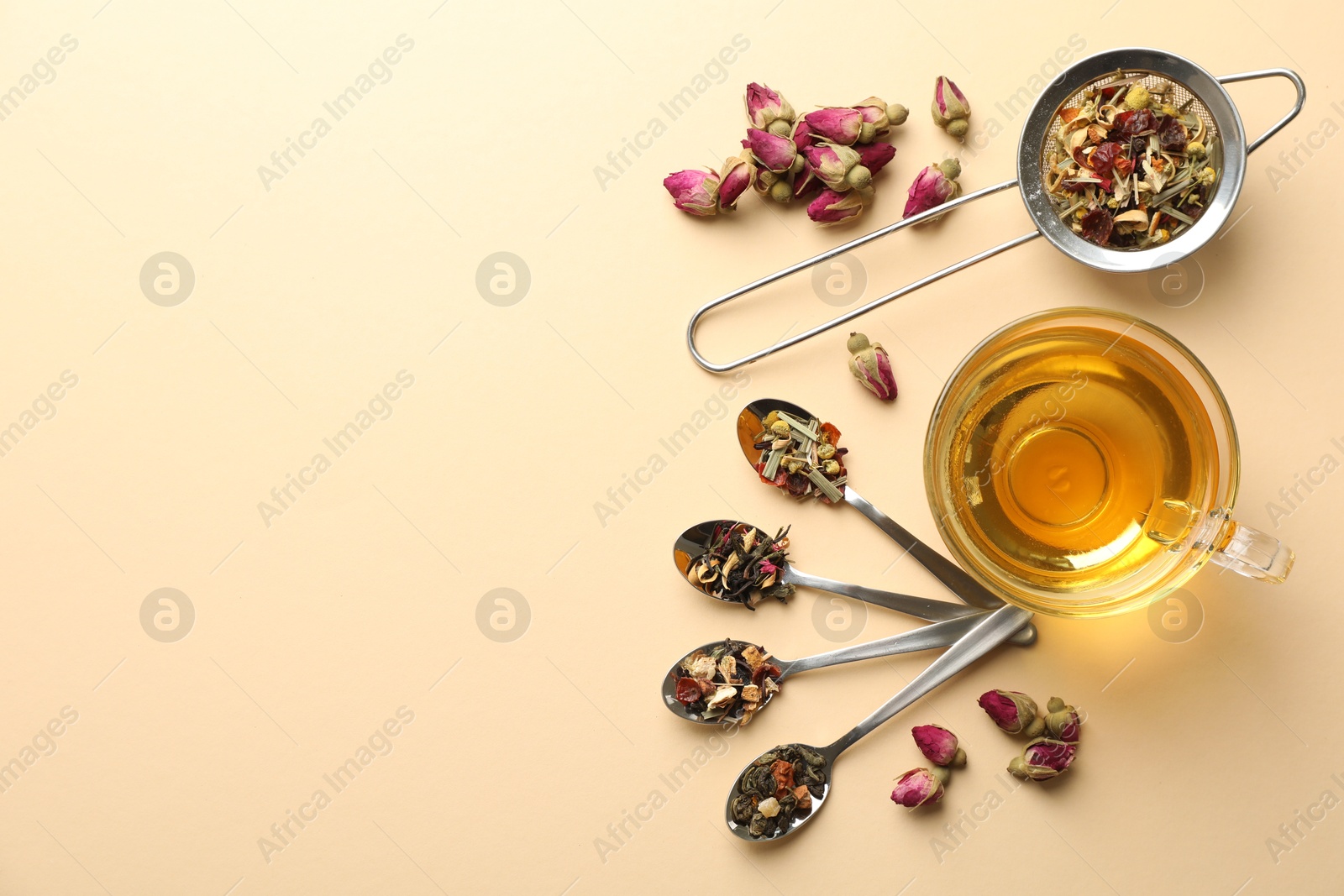 Delicious herbal tea in glass cup and dry leaves on beige background, flat lay. Space for text Photo of Delicious herbal tea in glass cup and dry leaves on beige background, flat lay. Space for text