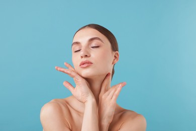 Photo of Portrait of charming young woman on light blue background
