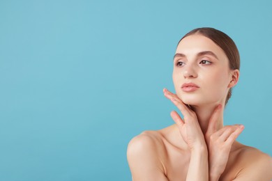 Photo of Portrait of charming young woman on light blue background. Space for text