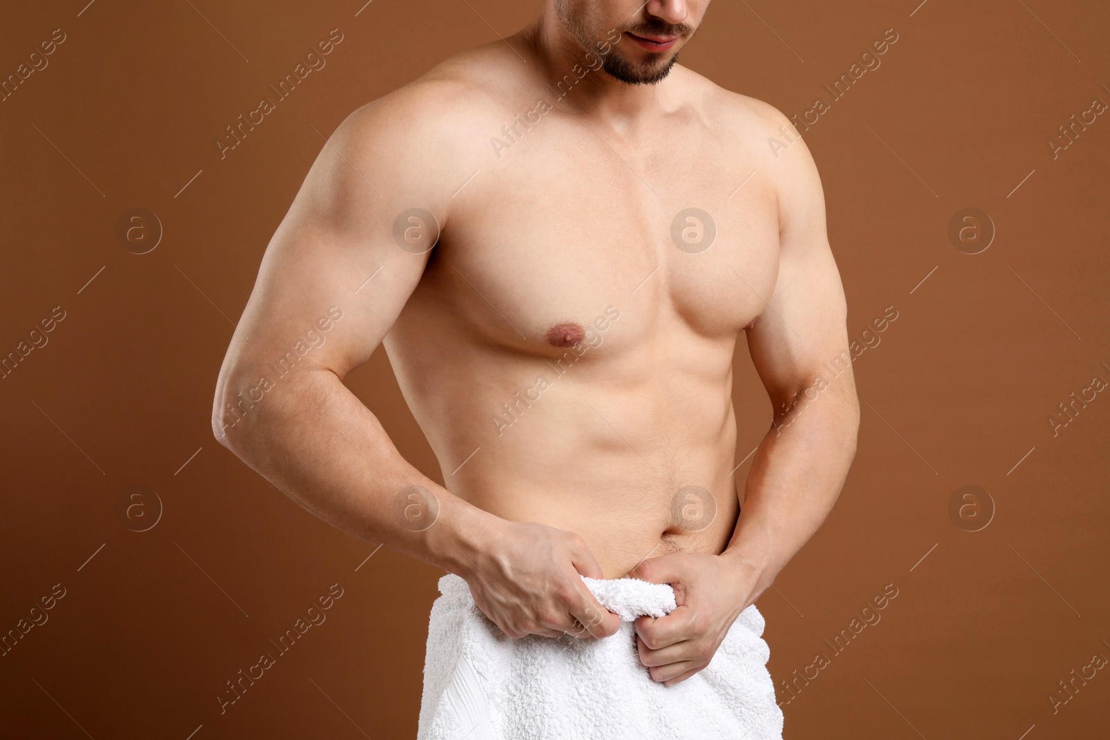 Young man with smooth chest after epilation procedure on brown background, closeup Photo of Young man with smooth chest after epilation procedure on brown background, closeup
