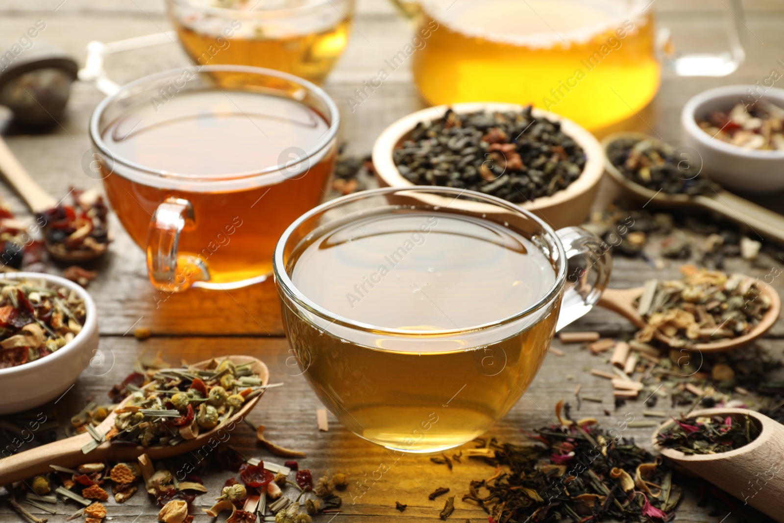 Different herbal teas and dry leaves on wooden table, closeup Photo of Different herbal teas and dry leaves on wooden table, closeup