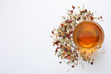 Photo of Delicious herbal tea and dry leaves on white background, top view. Space for text