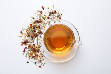 Photo of Delicious herbal tea and dry leaves on white background, top view